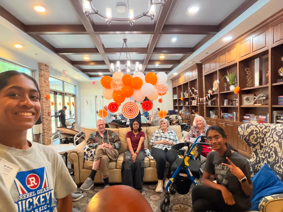 GrandPals volunteers and senior residents gathering at a decorated partner facility